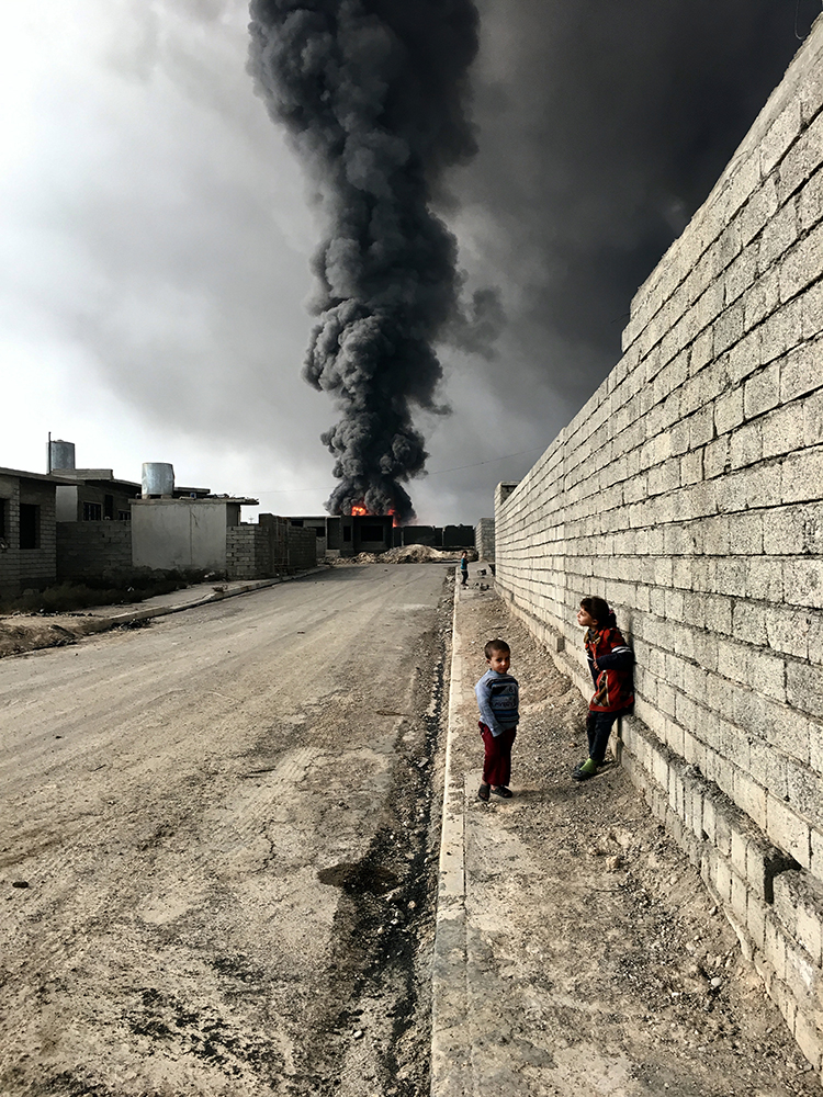 Sebastiano Tomada Brooklyn, New York Grand Prize Winner, Photographer of the Year iPhone 6s Children of Qayyarah “Children roam the streets in Qayyarah near the fire and smoke billowing from oil wells, set ablaze by ISIS militants.”