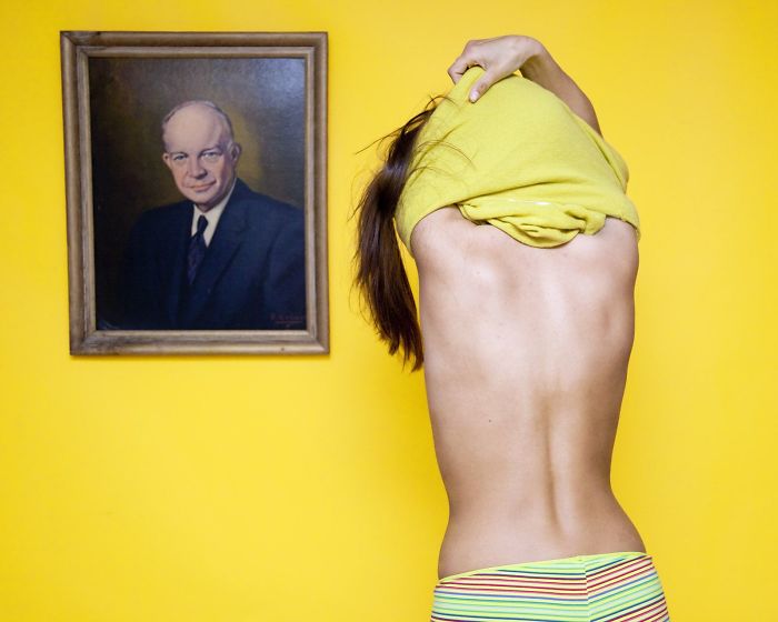 Olivia Locher I-fought-the-law-Ohio disrobe in front of portrait of a man